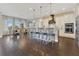 A gourmet kitchen featuring a spacious island with seating, hardwood floors, and modern stainless steel appliances at 16629 Broadwater Ave, Winter Garden, FL 34787