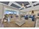 A modern living room featuring coffered ceilings, stylish furniture, and a seamless transition to outdoor living at 16629 Broadwater Ave, Winter Garden, FL 34787