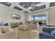 A modern living room featuring coffered ceilings, an entertainment center, and a sliding door to the backyard at 16629 Broadwater Ave, Winter Garden, FL 34787