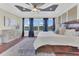 This is a bedroom with a water view, complemented by an ornate cabinet, a ceiling fan, and dark wood floors at 16629 Broadwater Ave, Winter Garden, FL 34787