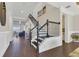 Elegant staircase with dark wood floors and black iron railings leads to the upper level of this beautifully designed home at 16629 Broadwater Ave, Winter Garden, FL 34787