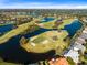 Stunning aerial view of a golf course community with lush landscaping, beautiful ponds, and well-maintained greens at 1720 Bridgets Ct, Kissimmee, FL 34744