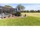 Landscaped backyard featuring a screened-in pool area and expansive green space at 1720 Bridgets Ct, Kissimmee, FL 34744