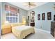 Bedroom featuring soft blue walls, a window, and doorway leading into a spacious bathroom at 1720 Bridgets Ct, Kissimmee, FL 34744