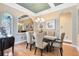 Formal dining room with stylish chandelier, art, and lots of natural light shining onto the wood floor at 1720 Bridgets Ct, Kissimmee, FL 34744