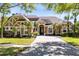Beautiful, sprawling home featuring tropical landscaping, stone accents, and a brick-paved driveway at 1720 Bridgets Ct, Kissimmee, FL 34744