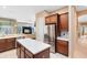Open kitchen layout that features wooden cabinets, a stainless fridge, an island and tile floors at 1720 Bridgets Ct, Kissimmee, FL 34744