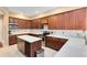 Well-lit kitchen featuring cherry cabinets, stainless appliances, an island and quartz countertops at 1720 Bridgets Ct, Kissimmee, FL 34744