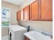 Functional laundry room with cabinets over the washer and dryer, window and tile floors at 1720 Bridgets Ct, Kissimmee, FL 34744