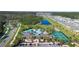 Aerial view showcasing community pool, tennis courts, and surrounding residences at 17398 Blazing Star Cir, Clermont, FL 34714