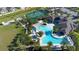 Beautiful aerial view of the community pool and pickleball courts, with tropical landscaping at 17398 Blazing Star Cir, Clermont, FL 34714