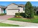 Charming home with brick-paved driveway, complemented by manicured landscaping and lush green grass at 17398 Blazing Star Cir, Clermont, FL 34714