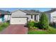 Charming single Gathering home with a paver driveway, two car garage, and manicured landscaping at 17398 Blazing Star Cir, Clermont, FL 34714