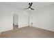 Neutral bedroom featuring carpet flooring, ceiling fan, and ensuite bathroom entrance at 1773 Groveline Rd, St Cloud, FL 34771