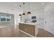 Bright open kitchen boasts white cabinets, stainless appliances, and a large island with pendant lighting at 1773 Groveline Rd, St Cloud, FL 34771