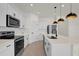 Well-lit kitchen features stainless steel appliances, white cabinets, and a spacious island with a deep sink at 1773 Groveline Rd, St Cloud, FL 34771