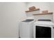 Convenient laundry room with washer, dryer, and floating shelves for storage at 1773 Groveline Rd, St Cloud, FL 34771