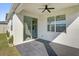 Covered patio features a ceiling fan, gray flooring, and sliding glass doors at 1773 Groveline Rd, St Cloud, FL 34771