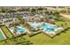 Aerial view of a community center with a pool and a grass court at 2087 Flora Pass Pl, Kissimmee, FL 34747