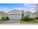 Charming single-story home featuring a two-car garage and beautifully landscaped front yard at 2087 Flora Pass Pl, Kissimmee, FL 34747