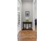 Hallway with a table between bathroom and bedroom entrances, featuring hardwood floors and neutral wall color at 2087 Flora Pass Pl, Kissimmee, FL 34747