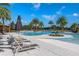 Resort-style pool area featuring palm trees, lounge chairs, and umbrellas perfect for relaxing and enjoying the Florida sunshine at 2087 Flora Pass Pl, Kissimmee, FL 34747