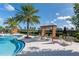 Resort style pool and lounge area with pergola and chairs, surrounded by palm trees and landscaping at 2087 Flora Pass Pl, Kissimmee, FL 34747