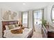 Inviting bedroom with natural light, a wooden bed frame, and leafy-themed decorations at 2099 Derwent Dr, Davenport, FL 33896