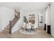 Elegant dining room with a round table, white chairs, modern light fixture, staircase, and decorative doors at 2099 Derwent Dr, Davenport, FL 33896