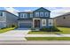 Charming two-story home with a well-manicured lawn and attached two-car garage at 2099 Derwent Dr, Davenport, FL 33896