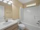 A clean bathroom with a light wood vanity, a full tub and shower, and a small window for natural light at 2200 Pine Needle Trl, Kissimmee, FL 34746