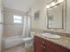 Well-lit bathroom with granite vanity, tile floors and shower with tub at 2200 Pine Needle Trl, Kissimmee, FL 34746