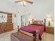 Comfortable bedroom, tiled floors, ceiling fan, warm lights and adjacent bathroom at 2200 Pine Needle Trl, Kissimmee, FL 34746