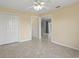 An inviting bedroom featuring a ceiling fan, neutral walls, and tile floor with an open doorway at 2200 Pine Needle Trl, Kissimmee, FL 34746