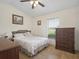 Bedroom with ample natural light, tiled floors, ceiling fan and a view to the golf course at 2200 Pine Needle Trl, Kissimmee, FL 34746
