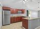 Kitchen with stainless steel appliances, granite counters, island and wood cabinets provides efficient cooking at 2200 Pine Needle Trl, Kissimmee, FL 34746