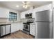 Well-lit kitchen with stainless steel appliances, granite countertops, and white cabinets at 2723 Beacon St, Eustis, FL 32726