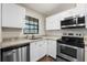 Bright kitchen features white cabinets, stainless steel appliances, granite countertops and a window at 2723 Beacon St, Eustis, FL 32726