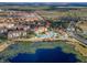 Beautiful aerial view featuring the community pool, lake, and lush green forest views in a resort setting at 2784 Almaton Loop # 301, Kissimmee, FL 34747