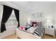 Bedroom with Mickey Mouse decor, including a comfortable bed, artwork, and window with curtains at 2784 Almaton Loop # 301, Kissimmee, FL 34747