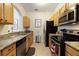 Well-lit kitchen featuring stainless steel appliances, wooden cabinetry, and tiled floors at 2784 Almaton Loop # 301, Kissimmee, FL 34747