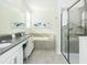 Bright bathroom featuring double vanity, soaking tub, and glass-enclosed shower with modern fixtures at 2807 Bookmark Dr, Kissimmee, FL 34746