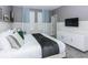 Modern bedroom with two-tone walls, plush bedding, white dresser, and a wall-mounted TV at 2807 Bookmark Dr, Kissimmee, FL 34746