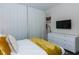 Comfortable bedroom features a soft yellow throw, wall art and a white dresser at 2807 Bookmark Dr, Kissimmee, FL 34746