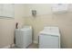 Bright laundry room with white washer and dryer, shelving for storage, and neutral walls at 2807 Bookmark Dr, Kissimmee, FL 34746