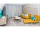 Cozy living room with a yellow sofa, round tables, stylish wallpaper, and ample natural light at 2807 Bookmark Dr, Kissimmee, FL 34746
