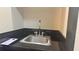 A single sink with a chrome faucet set in a dark countertop next to a stack of door hangers at 3000 Maingate Ln # 227, Kissimmee, FL 34747