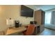 A well-equipped workspace includes a desk, chair, TV, coffee maker, and closet for convenience at 3000 Maingate Ln # 227, Kissimmee, FL 34747