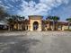 Exterior view of clubhouse with ample parking and palm trees at 3026 Bella Vista Dr, Davenport, FL 33897