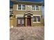 Two-story townhome with a brick driveway and classic architectural details at 3026 Bella Vista Dr, Davenport, FL 33897